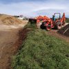 Building a windrow of bulk compost.
